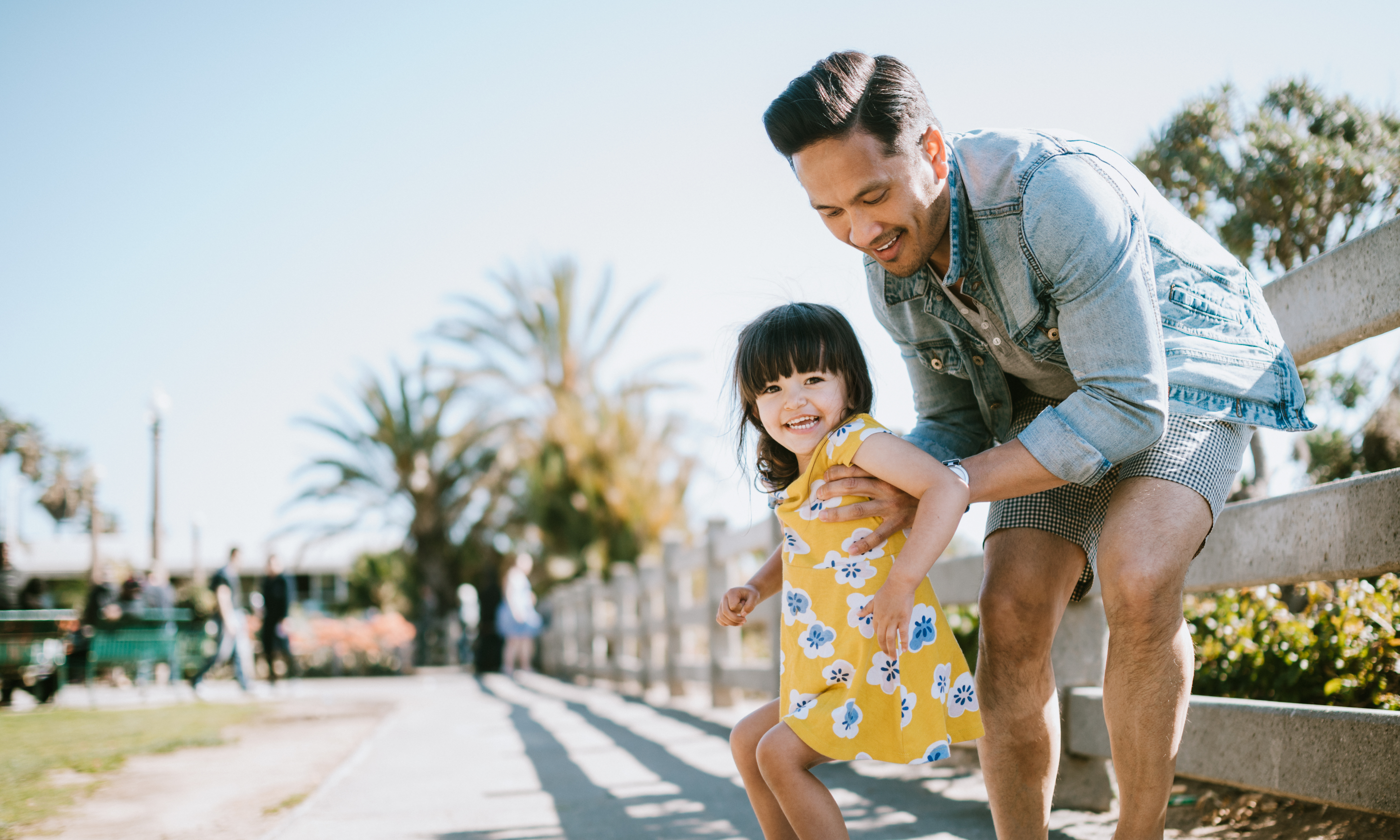 Asian American father and young daughter having fun outside