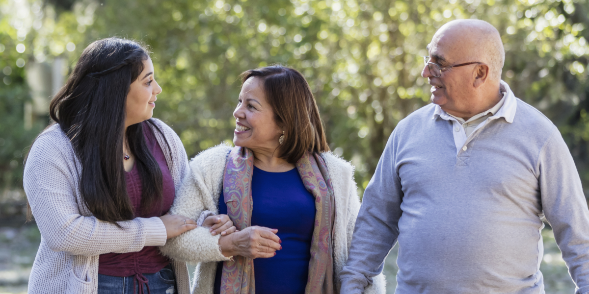 Older adult parents with their adult child outside